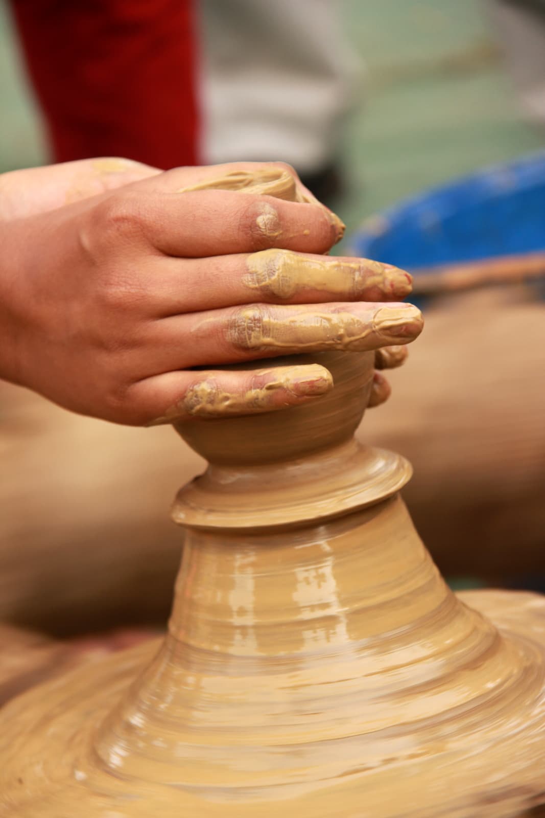 Bàn tay nặn gốm trên bàn xoay